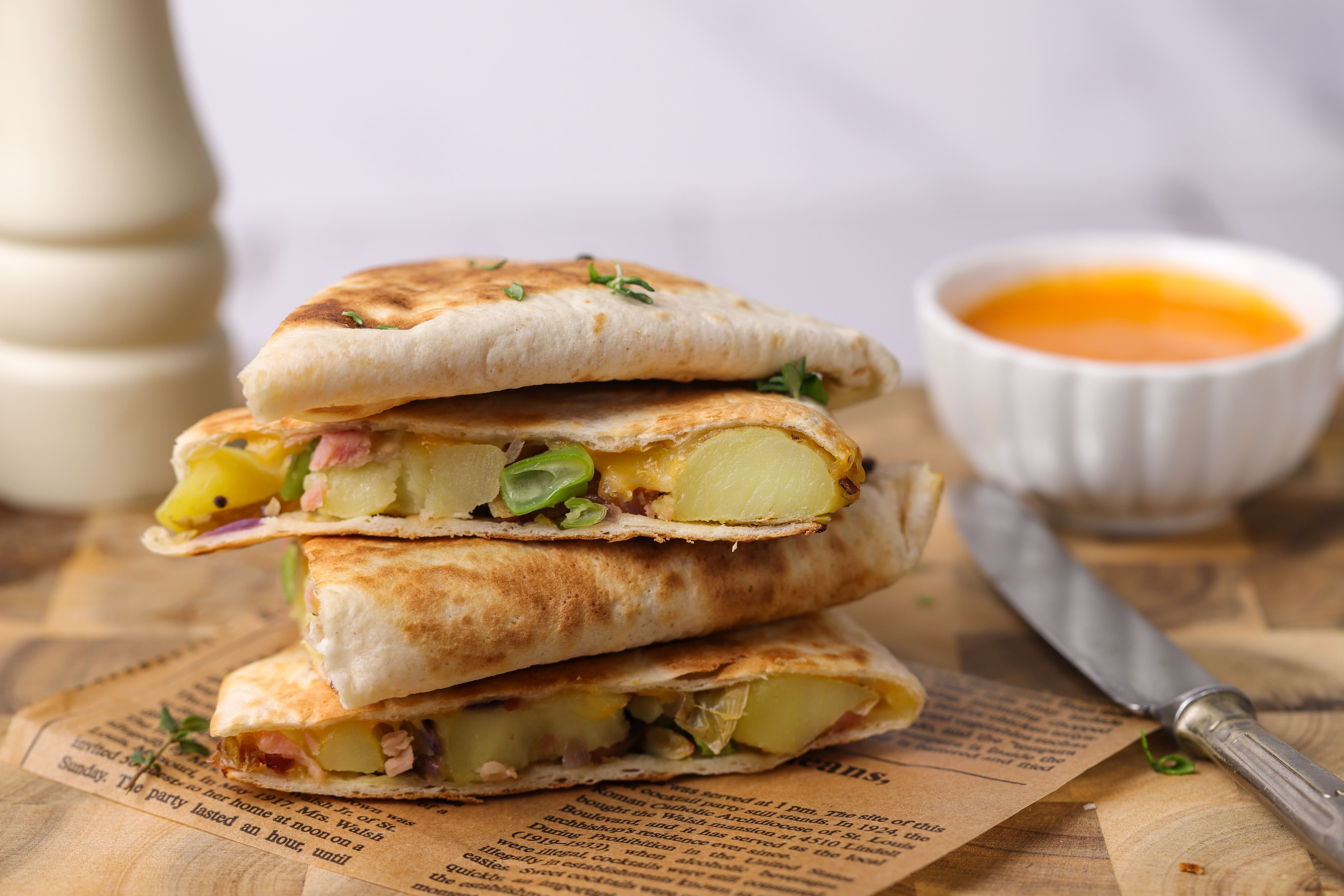 Golden toasted quesadillas cut into triangles, filled with melted cheese, potatoes, ham and greens, served with mayo on the side.