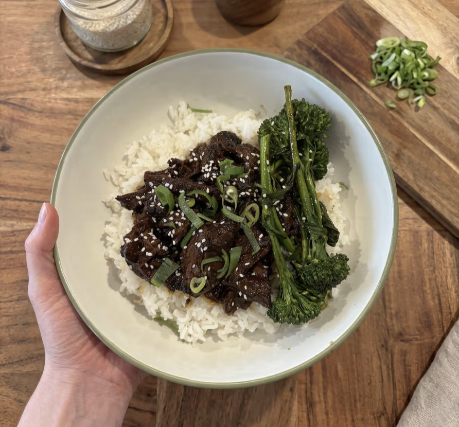 Shredded miso and ginger beef in a glossy sauce, served over white rice with steamed broccolini and sliced spring onions