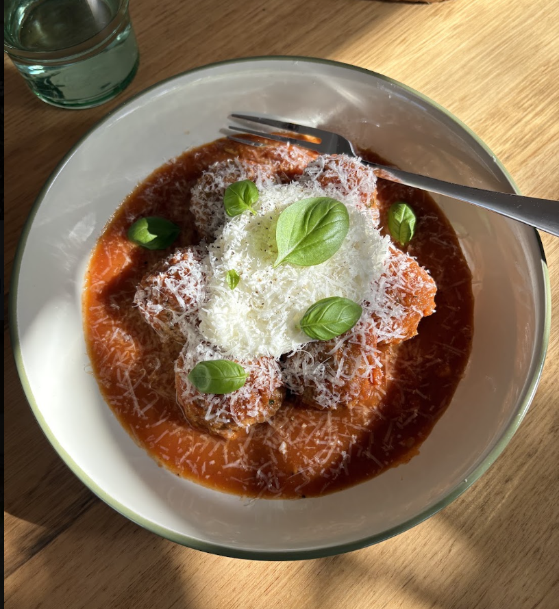Browned pork meatballs in a rich tomato sauce, topped with dollops of ricotta, fresh basil leaves and grated parmesan
