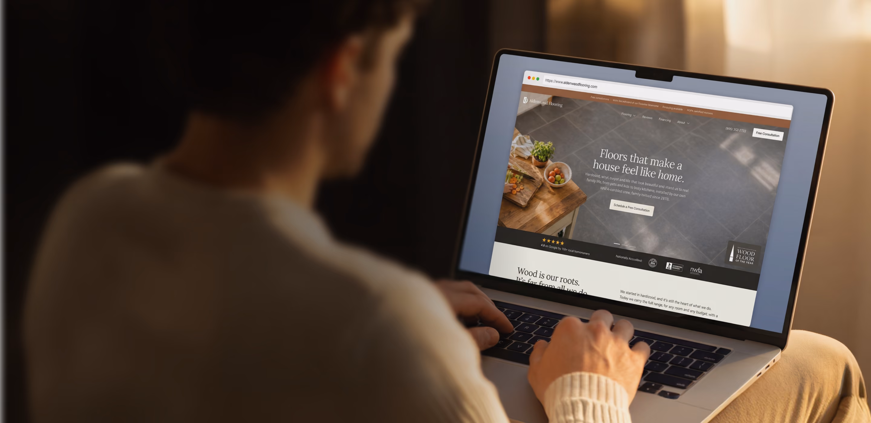 Homeowner browsing a Blaze-built flooring website on a laptop