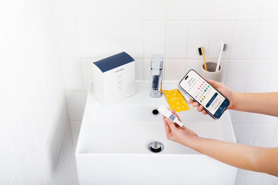 Testing at home: an Oova strip and the Oova app on a bathroom sink