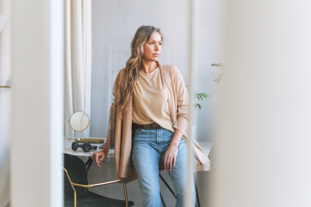 A woman standing in a bright room, looking ahead