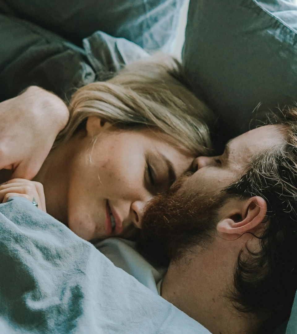 A couple resting close together in bed