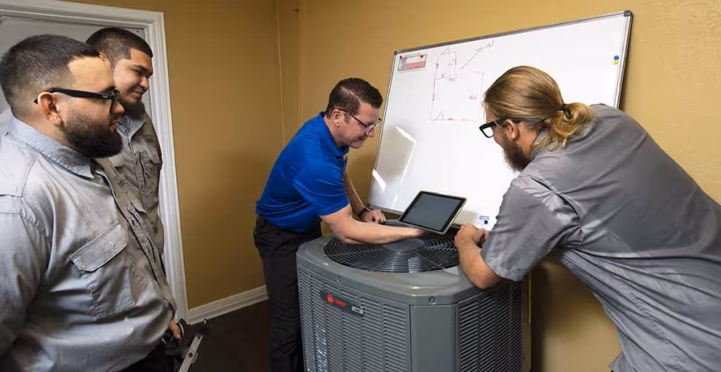 AC technicians at Tiger Heating & Air with air conditioner in Corpus Christi HVAC shop
