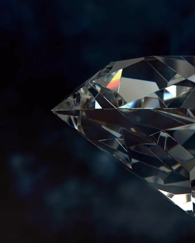 Close-up of a clear, faceted diamond set against a dark, blurred background.