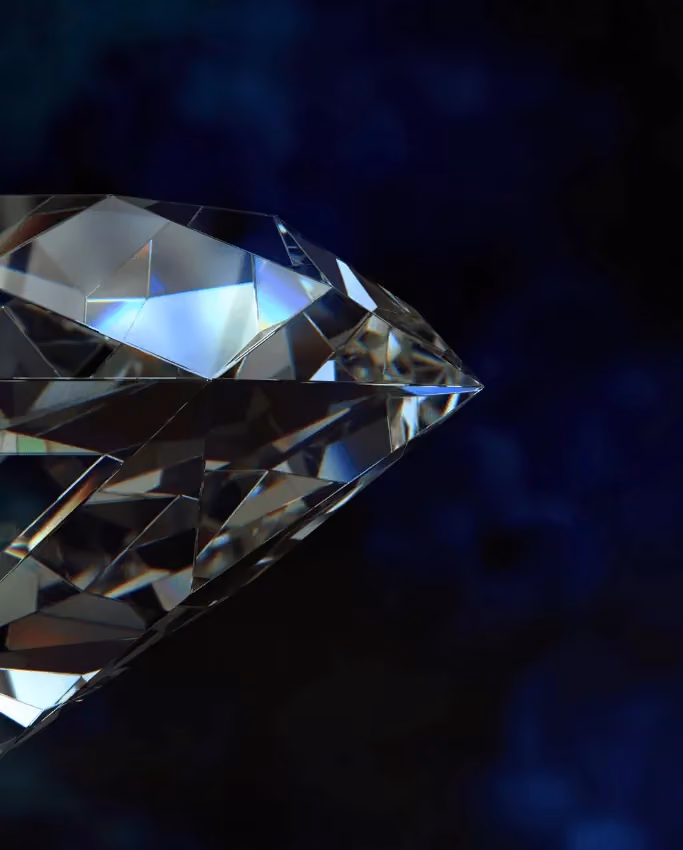 Close-up of a sparkling diamond with detailed facets reflecting light against a dark blue background.