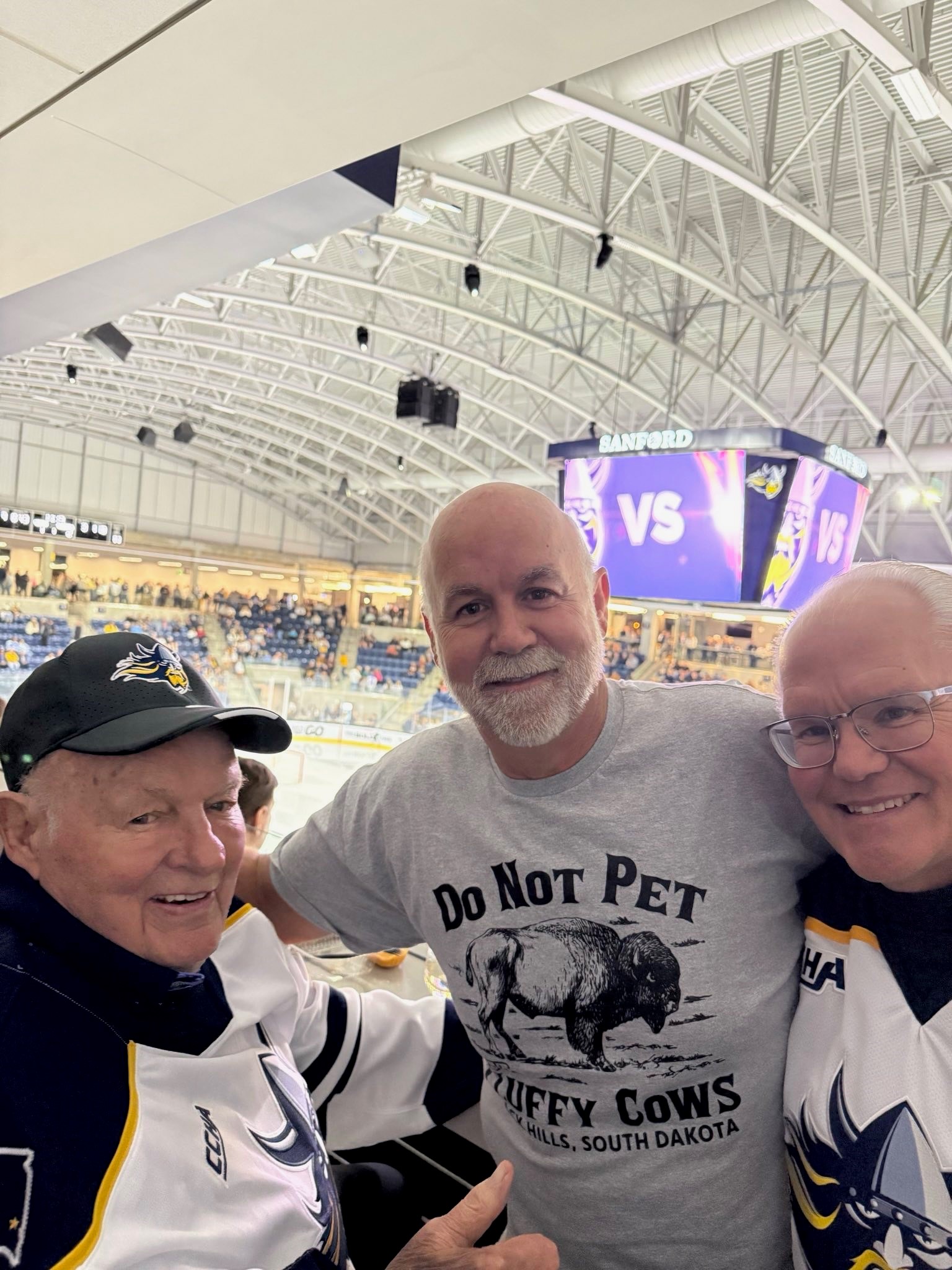 Denny Sanford and sons at Augustana Hockey game.