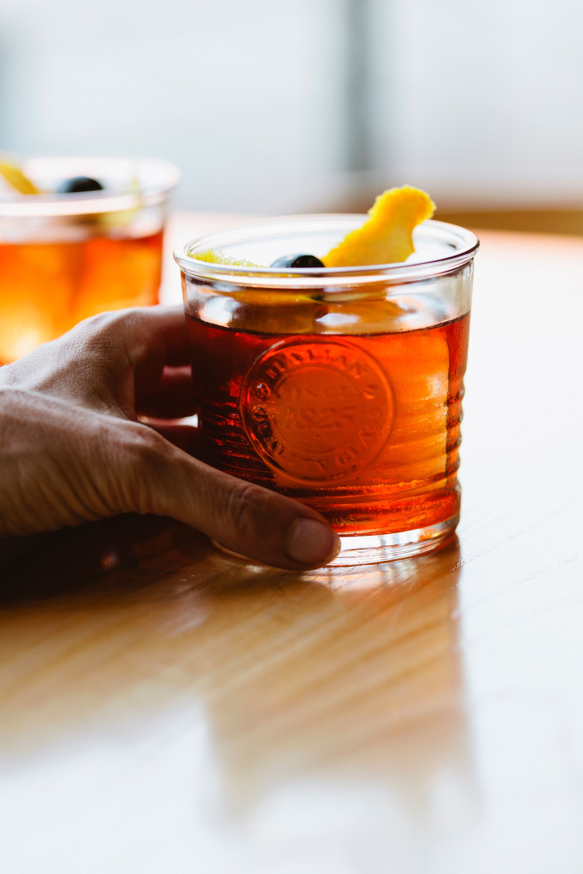 hand holding orange cocktail