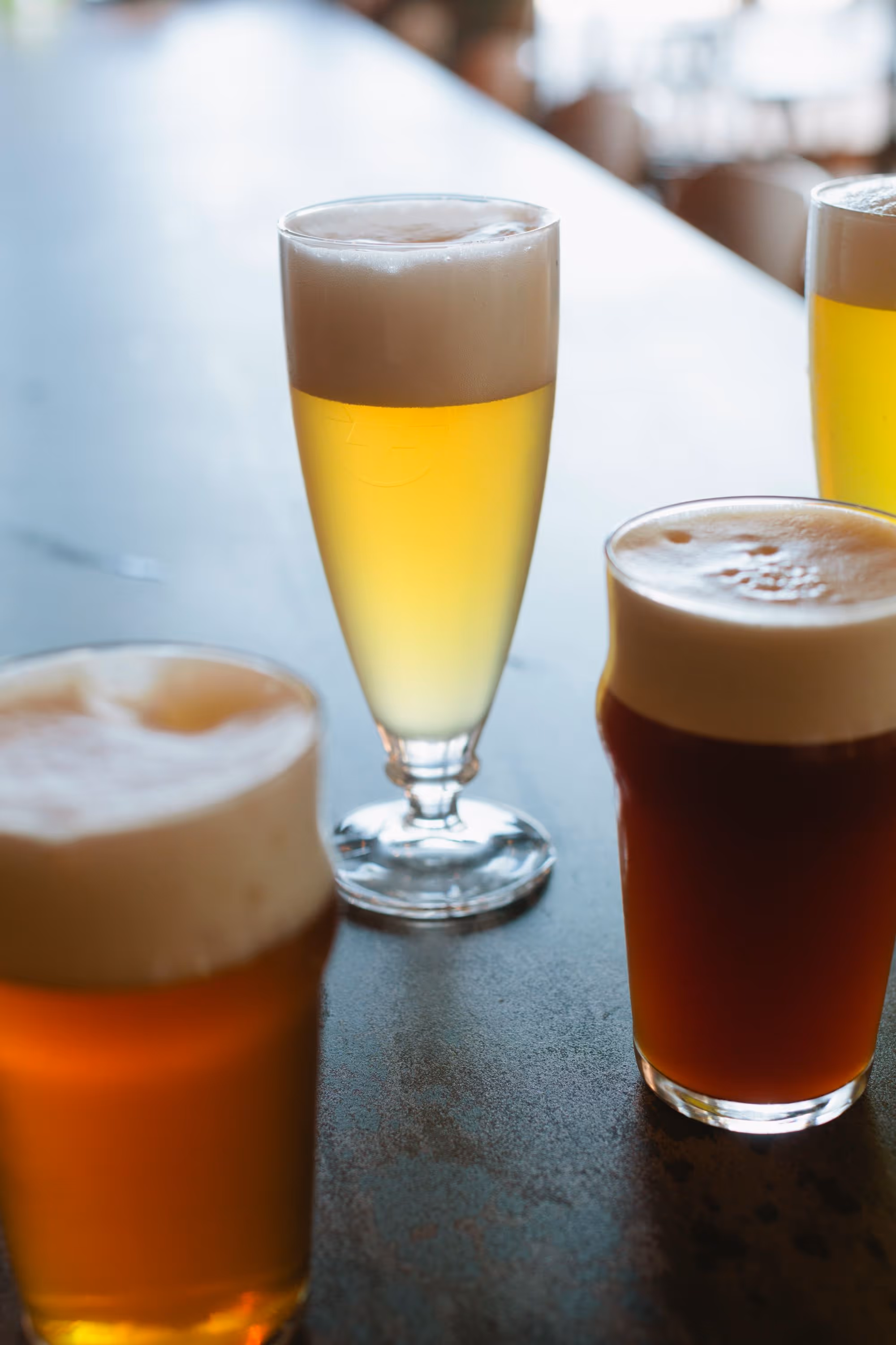 foamy beers on wooden surface