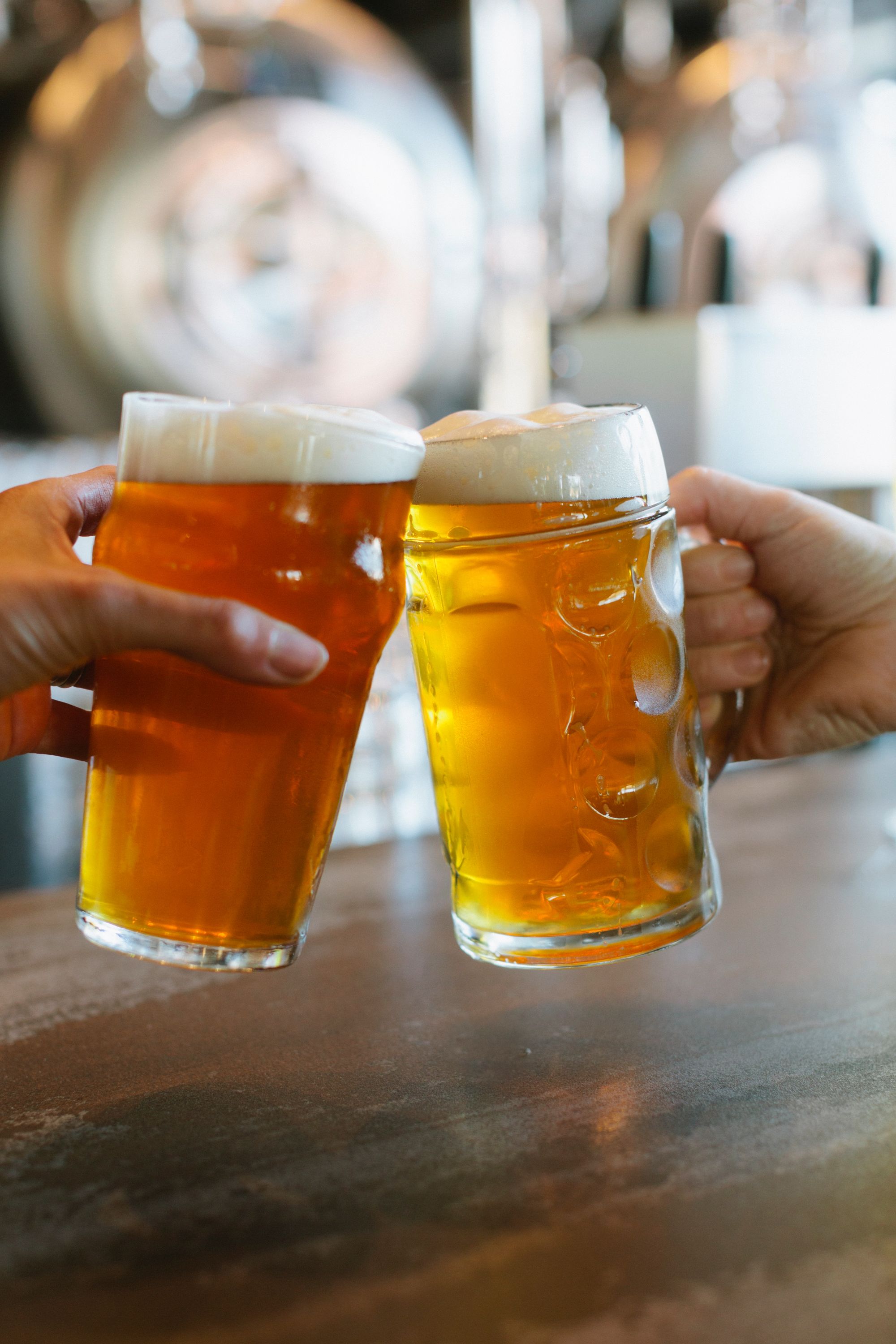 two hands toasting with beers