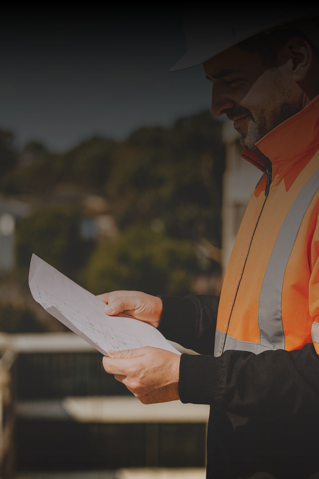 Sydney building inspector in high-visibility vest reviewing structural plans during a detailed building investigation and report.