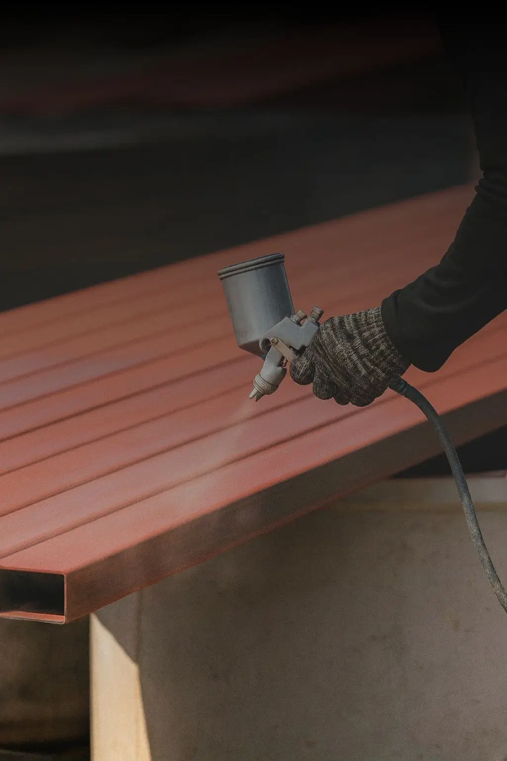Worker applying protective coating to a steel beam surface.