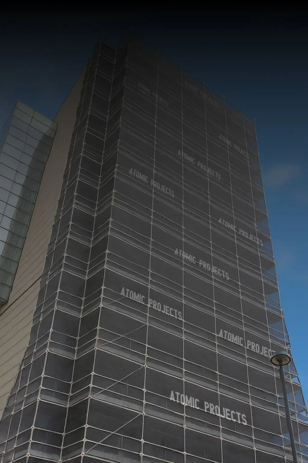 High-rise façade under scaffold during combustible cladding replacement, ensuring compliance with NCC fire safety standards.