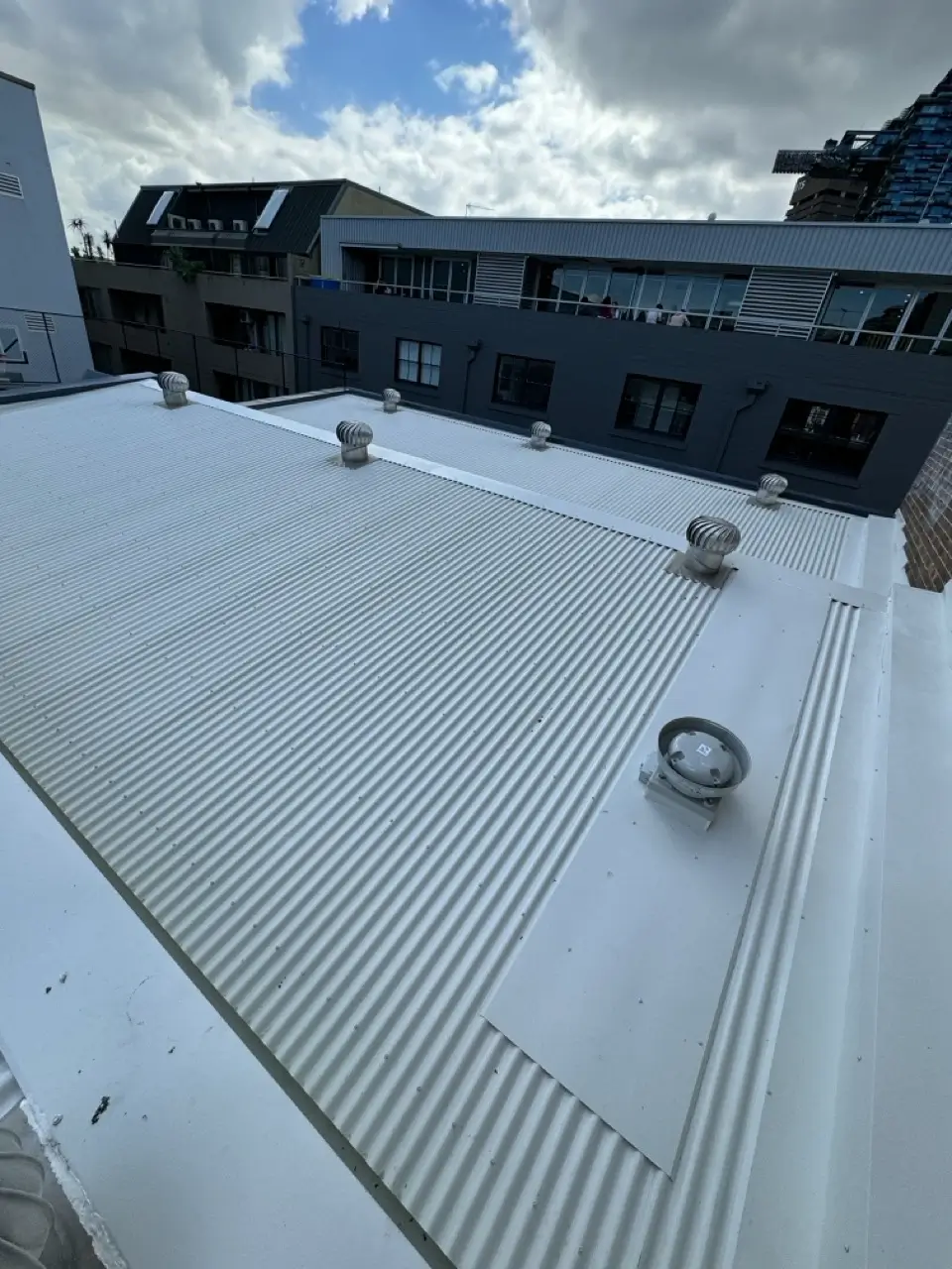 Metal roof replacement at Henrietta St, Chippendale — new roof sheeting with vent penetrations flashed and sealed