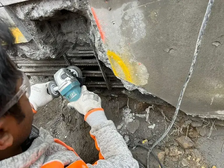 Concrete pool remediation at Coolong Rd, Vaucluse — technician treating the exposed reinforcement with a grinder