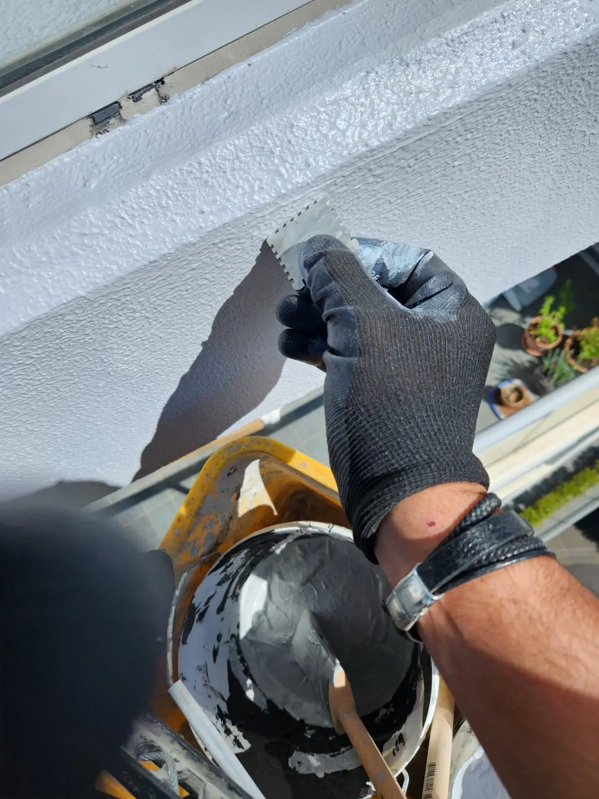 Facade repair at Sergeants Lane, St Leonards — technician hand-finishing render on the repaired concrete
