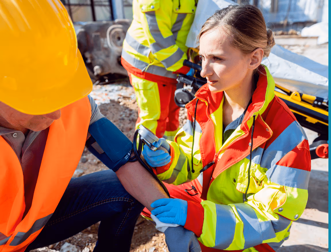 A medical professional is onsite checking a construction worker's blood pressure.