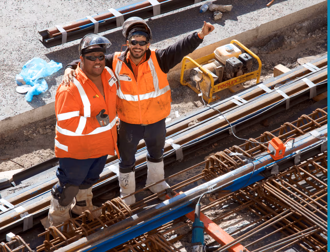 Construction workers onsite surrounded by tools and metal.