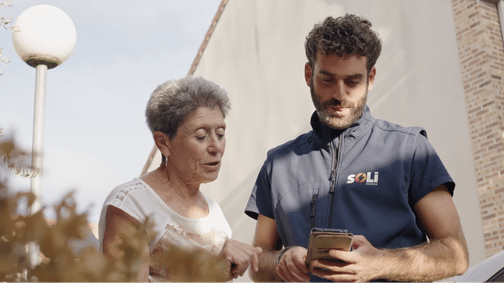 Un conseiller Soli explique à une cliente comme utiliser l'application de suivi des performances de son installation.