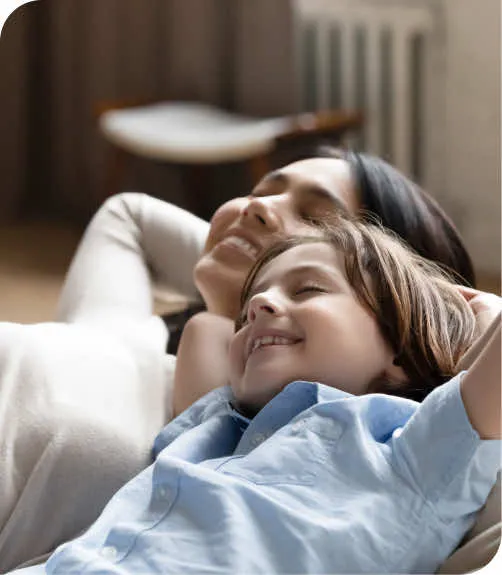 A woman and a child laying on a bed.