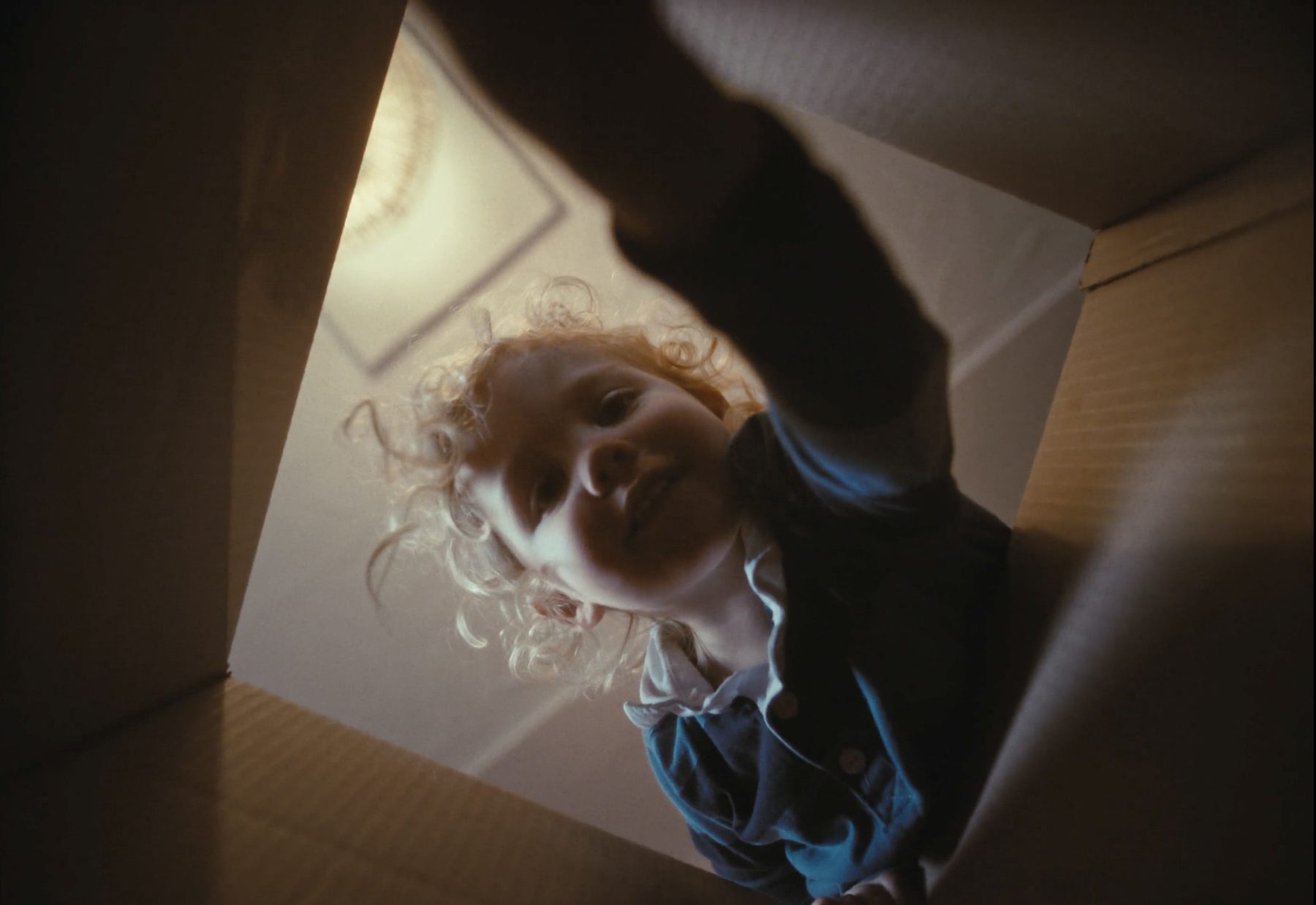Frame from Room to Grow: a toddler looking into a moving box