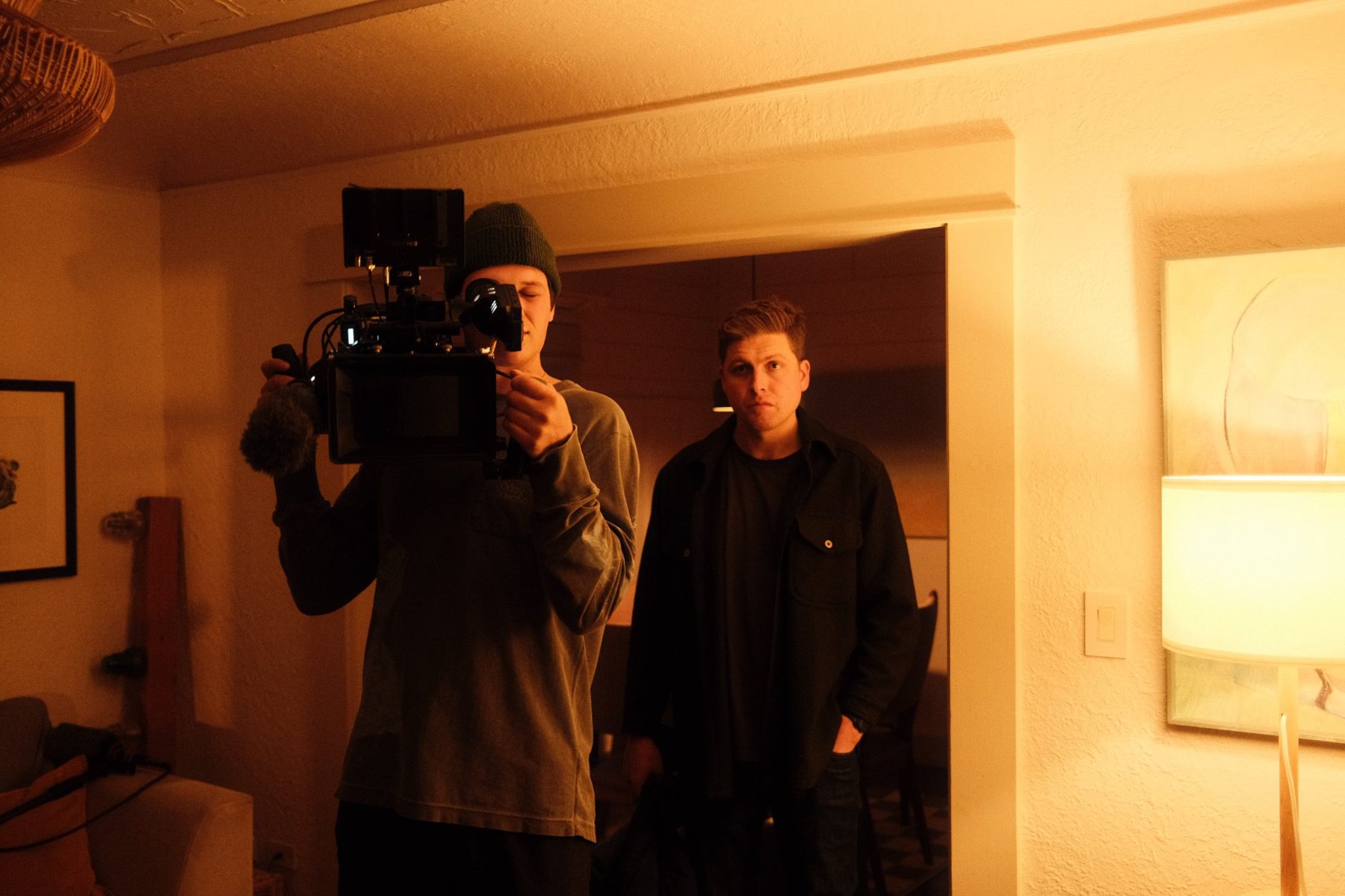 Behind the scenes: camera operator in a tungsten-lit living room