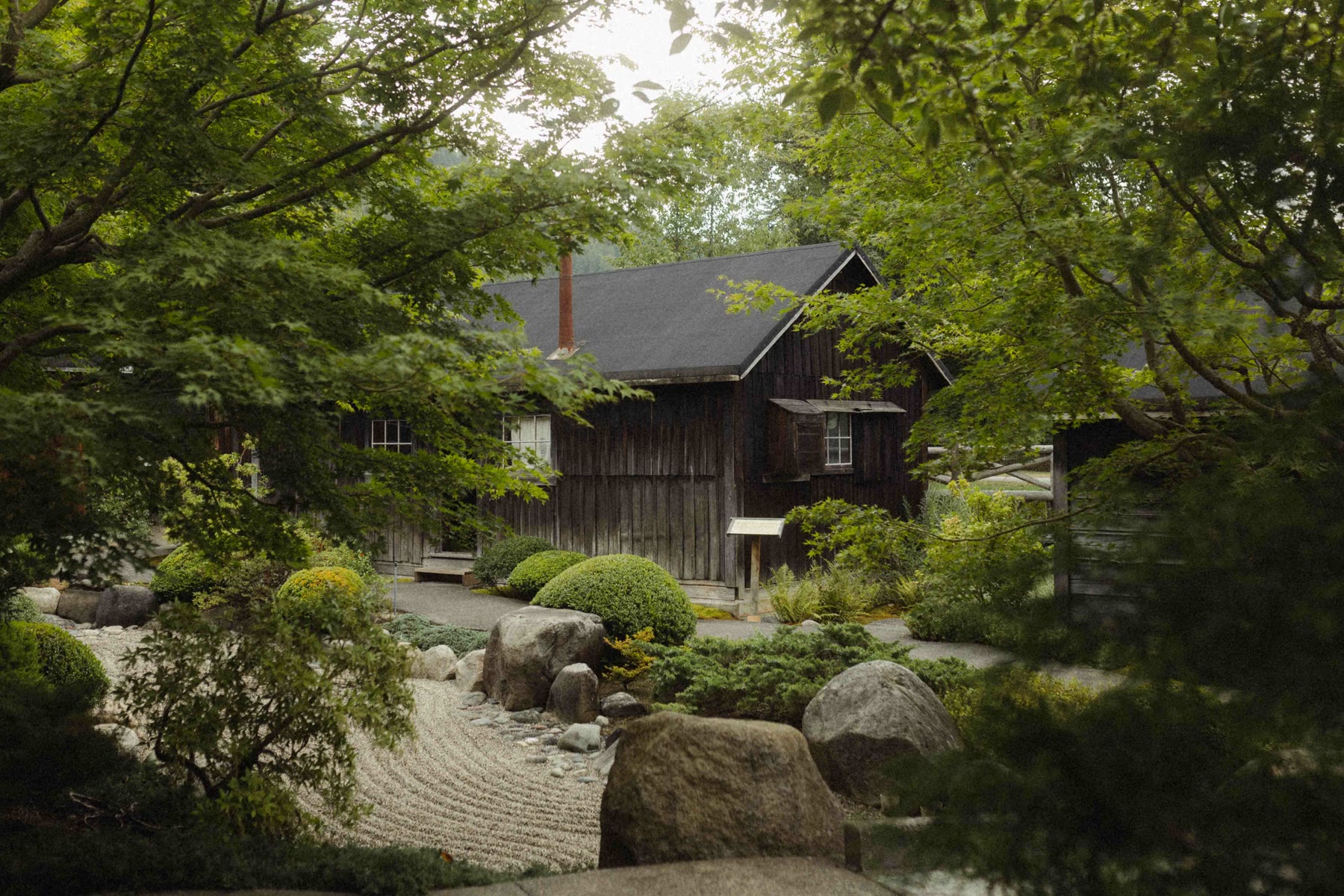 A raked gravel garden beside historic wooden buildings