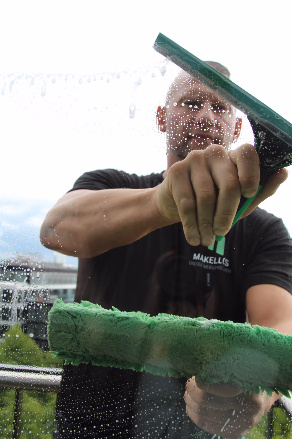 Makellos Mitarbeiter am Fenster putzen