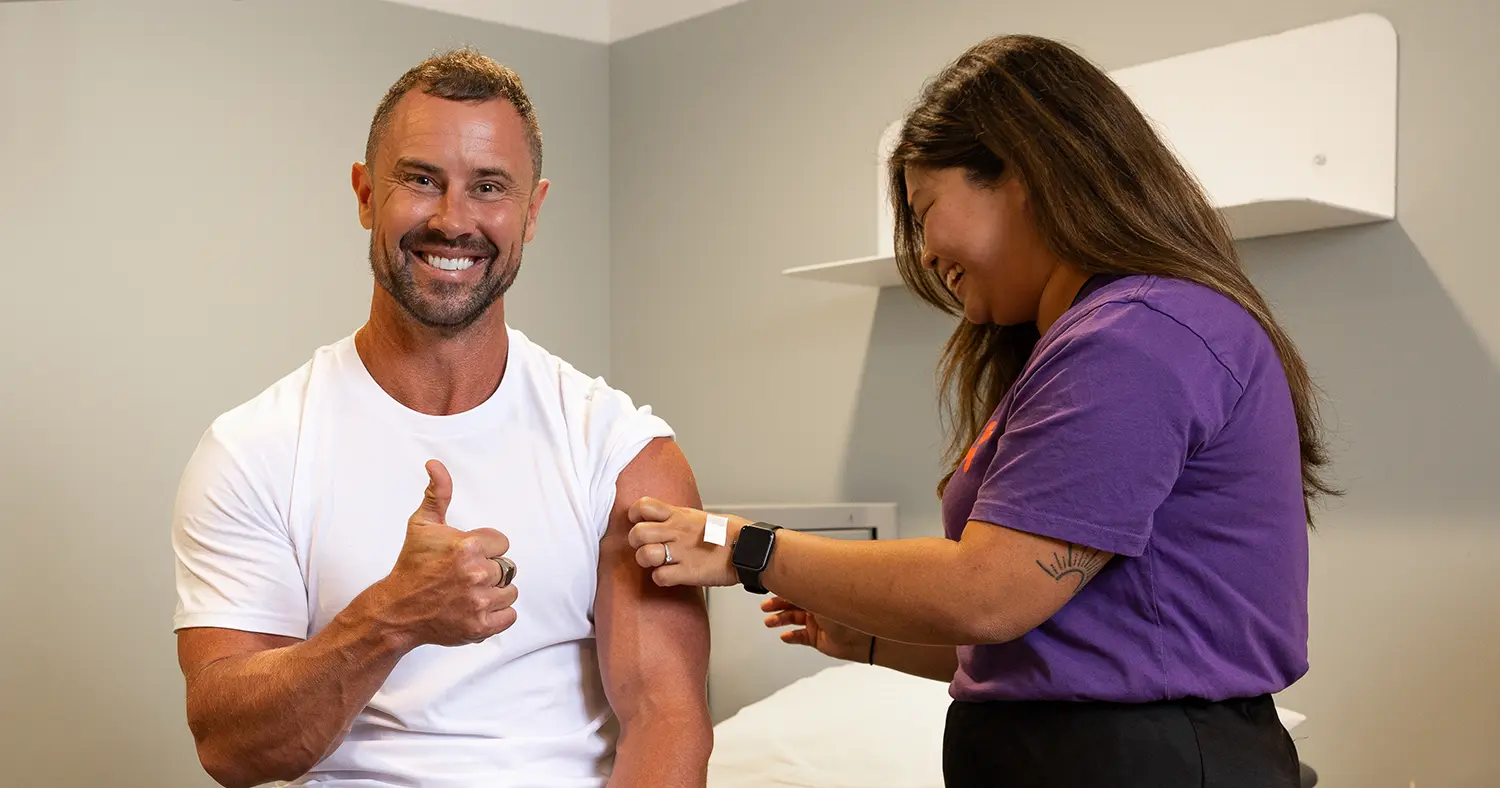Sam Wallace giving the thumbs up while Nurse Jeanette sticks a plaster on his arm after a flu shot