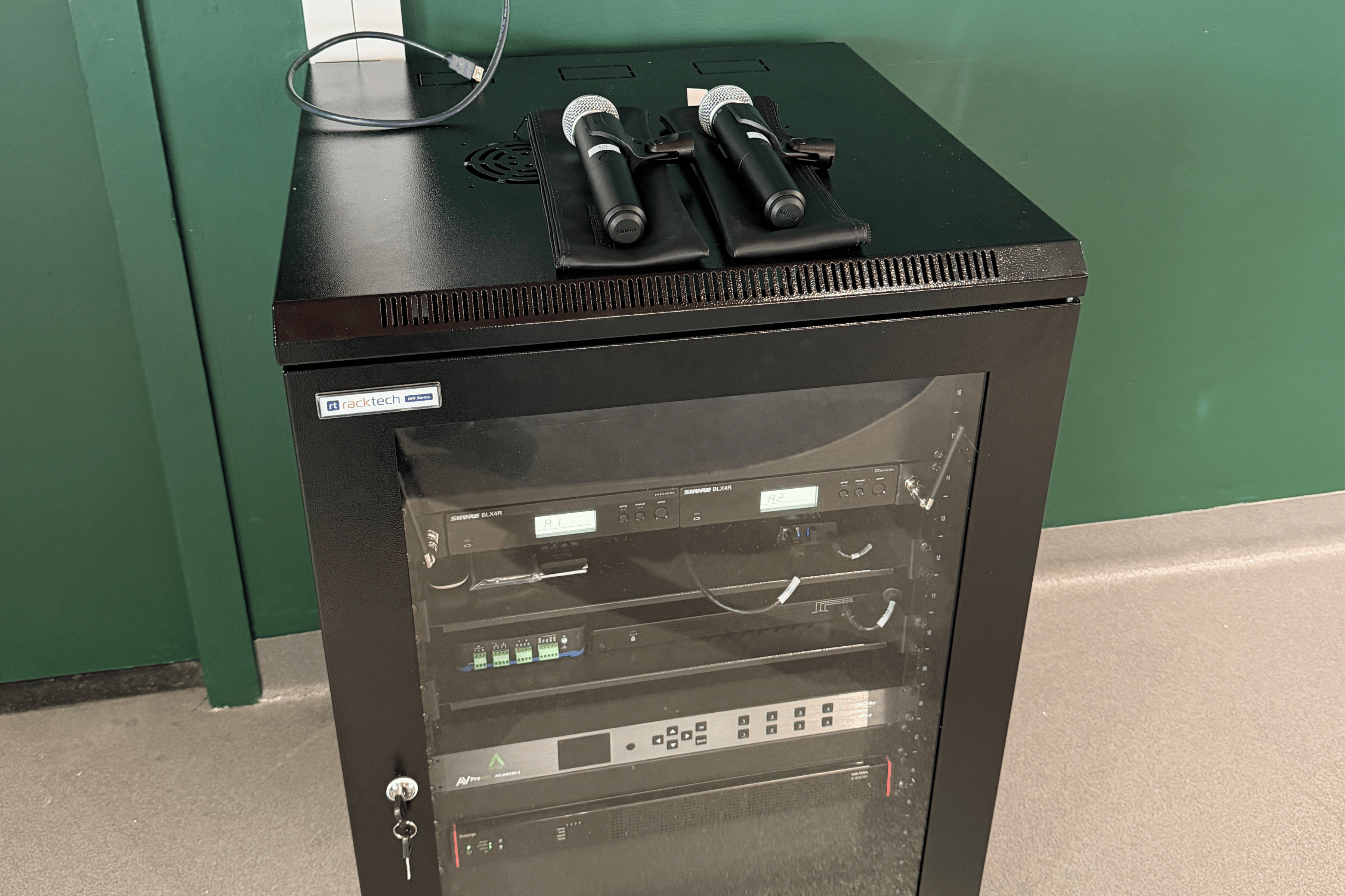 Floor-standing AV rack with wall-mounted touch panel above