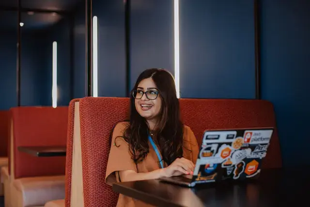 Woman smiling and using her laptop.