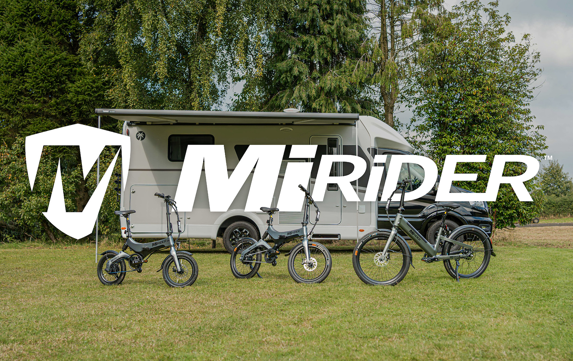 3 Mirider cycles in front of a camper van, with logo overlaid
