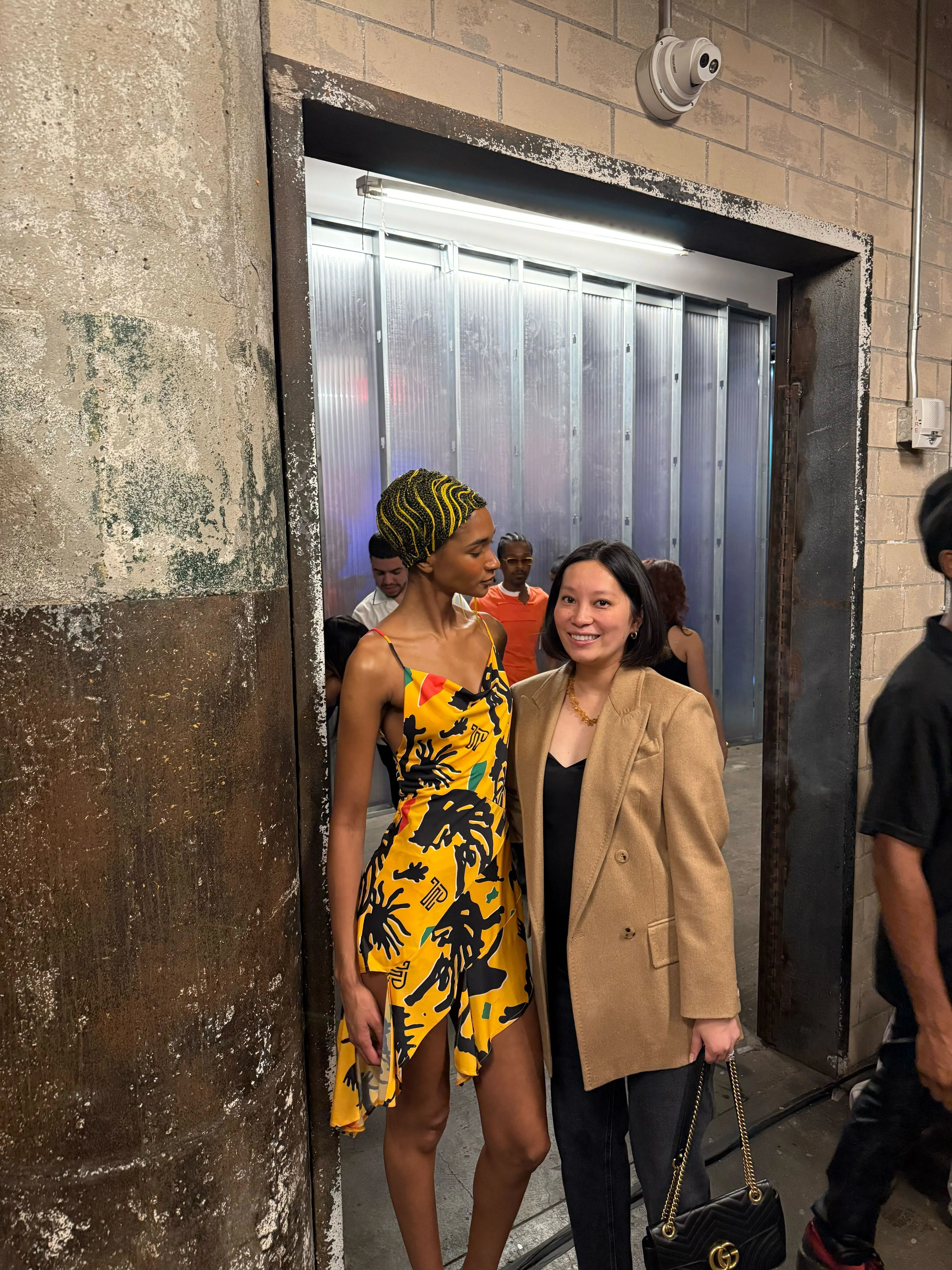 Two people at an indoor event with other attendees in the background