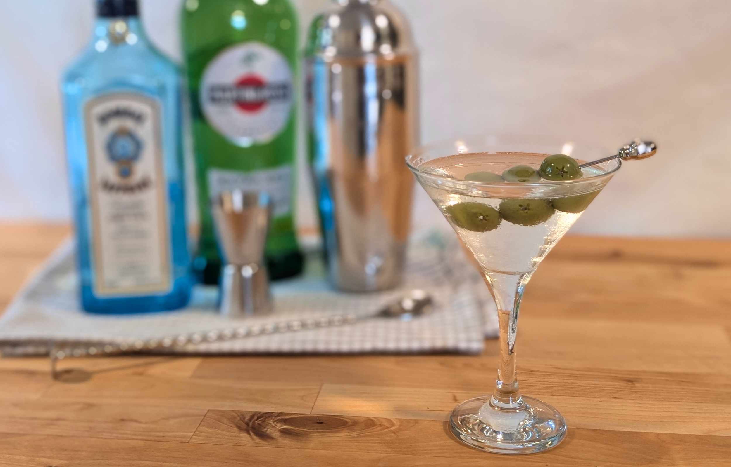 Gin martini with olives on a cocktail pick