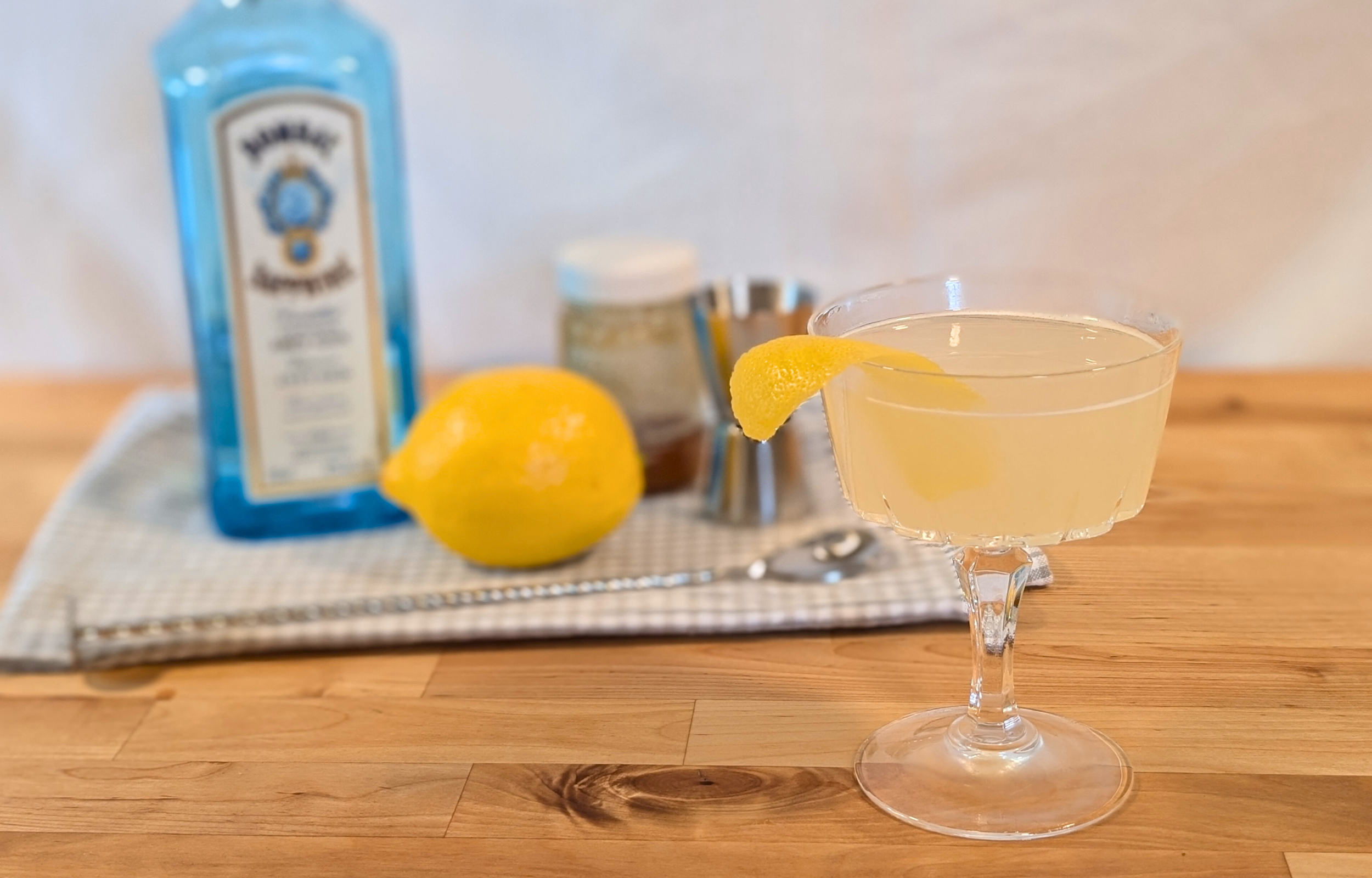 Bee's Knees cocktail with a lemon twist