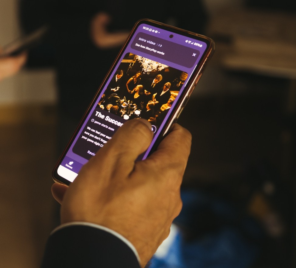 Hand holding a phone with the StoryPop app