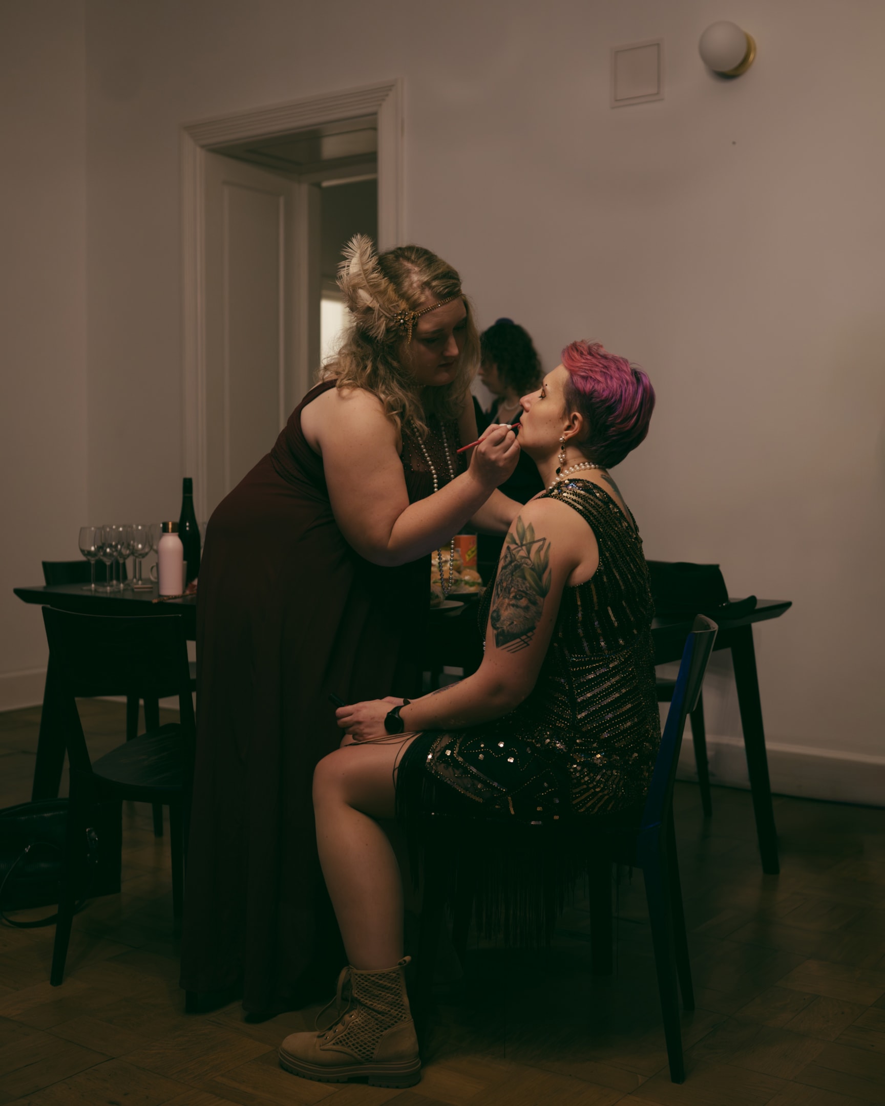 1920s themed murder mystery party guests applying makeup