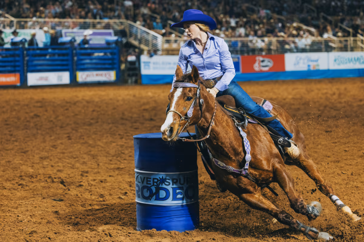 Barrel racer makes a tight turn around a barrel at the Silver Spurs Rodeo.