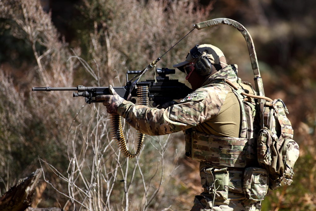 a man dressed in camoflauge and holding a gun