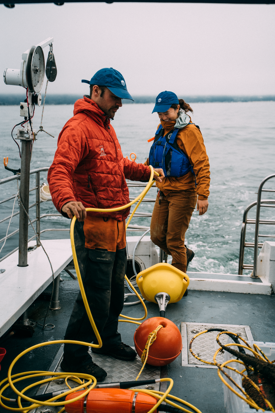 Research team preparing Spotter Smart Mooring system for deployment on vessel deck with yellow buoy and mooring equipment