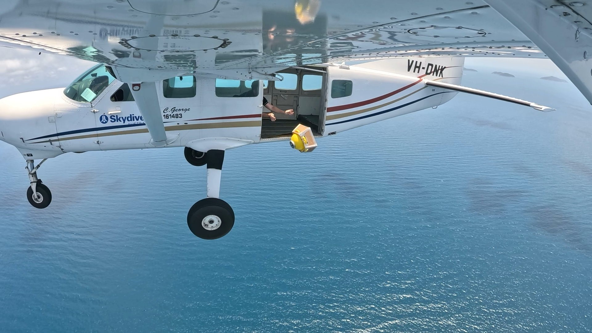 A Spotter exits a light aircraft over the Coral Sea, deployed into the forecast path of an approaching cyclone.