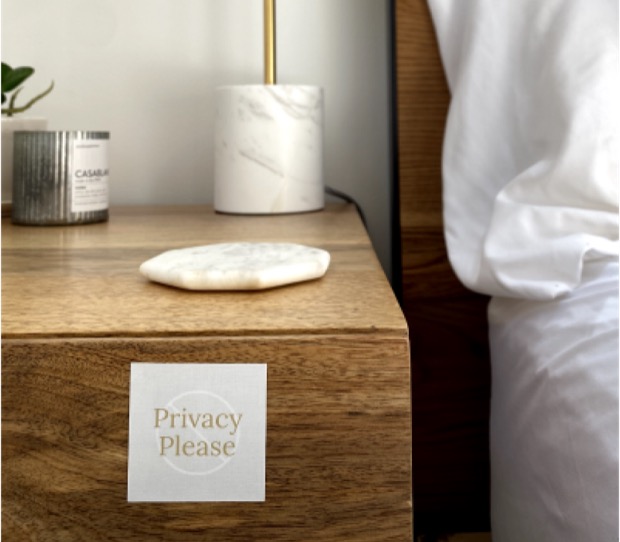 A Privacy Please card on a bedside table