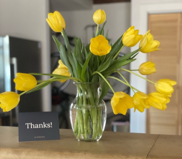Yellow tulips beside a handwritten thank-you card