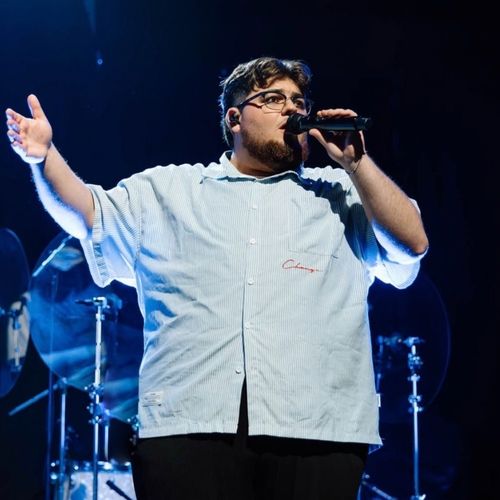 Enoch on stage singing into a microphone