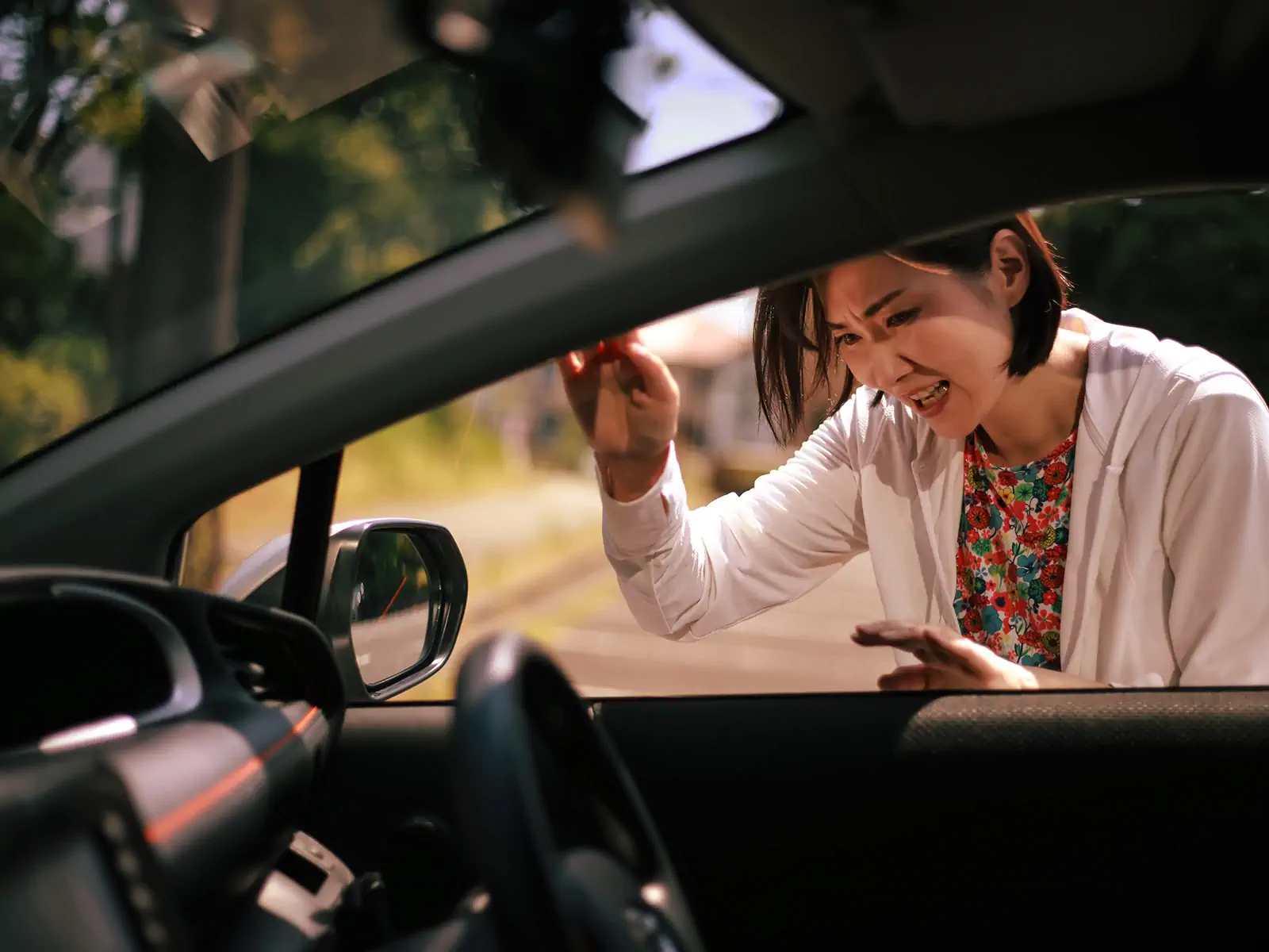A woman locked out of her car looking frustrated