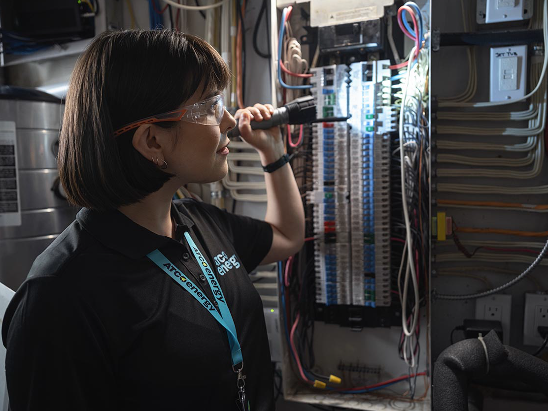 An ATCO energy technician inspecting electrical systems.