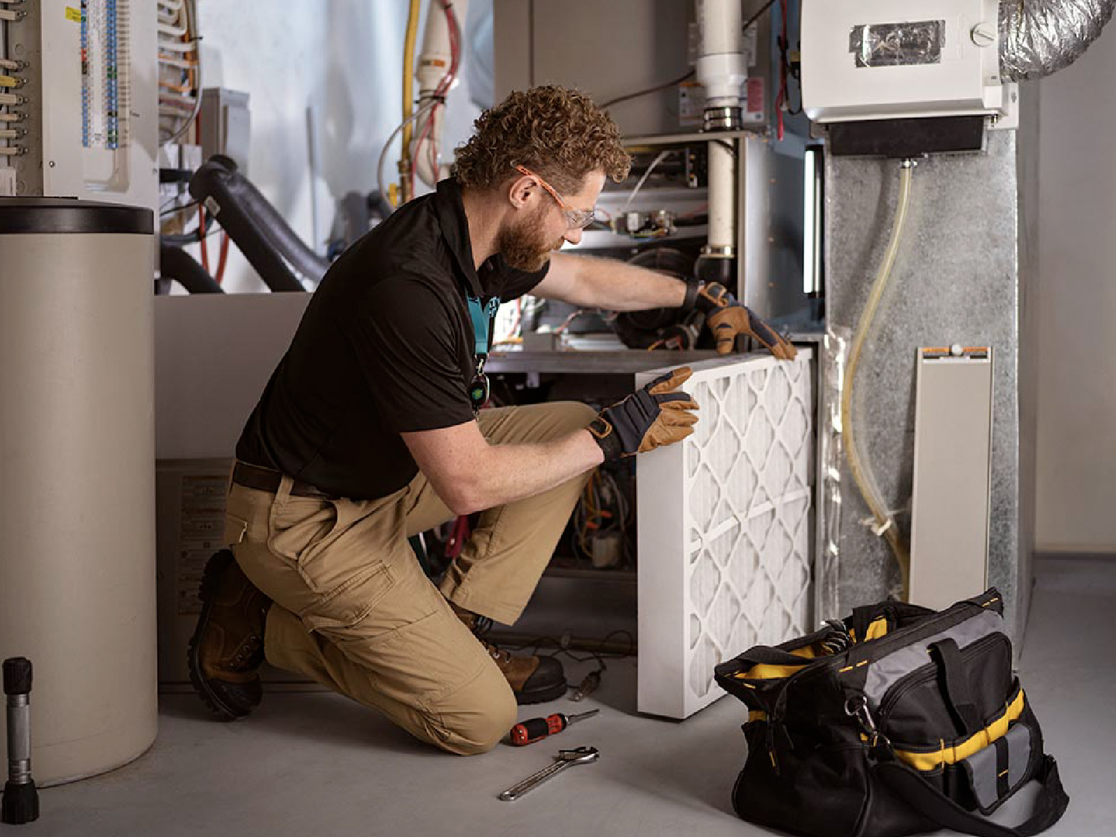 An ATCO energy technician inspecting a furnace.
