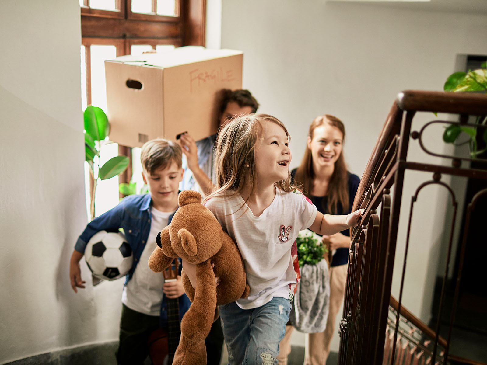 A family walking up the stairs in their new home