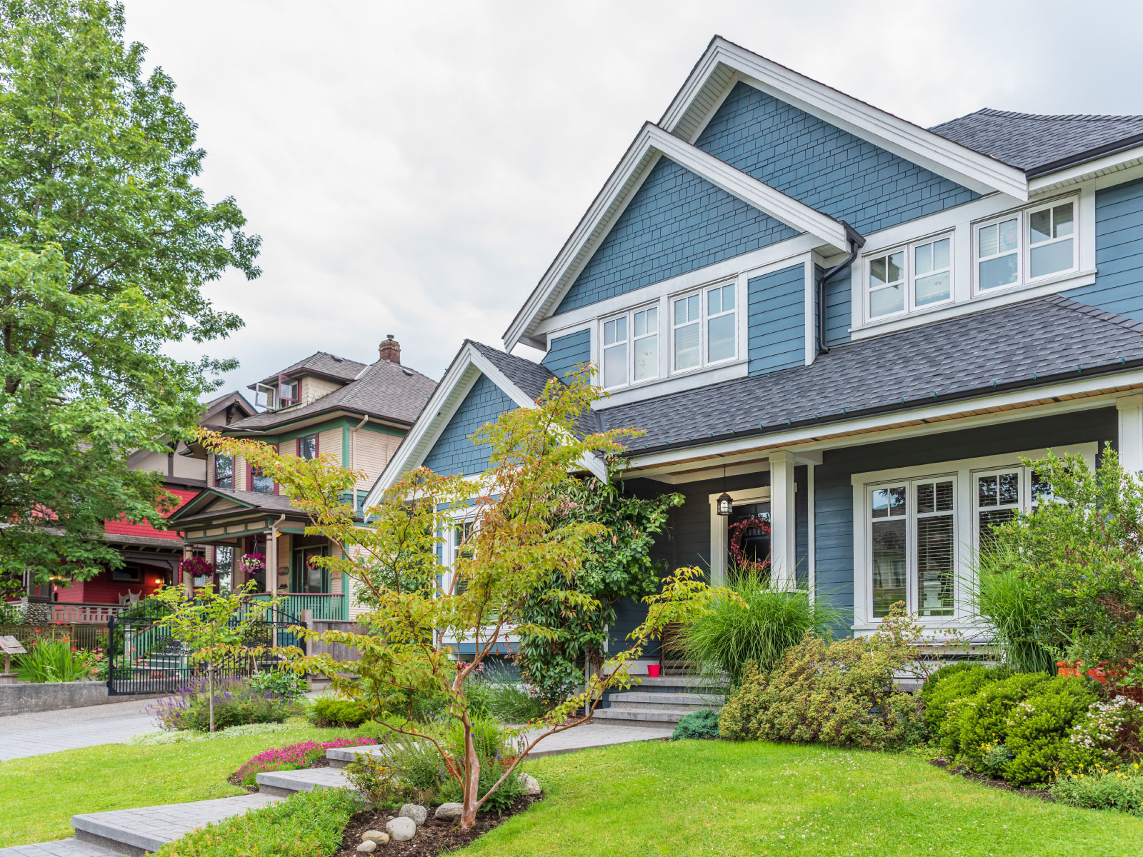  A blue detached home with a green lawn.