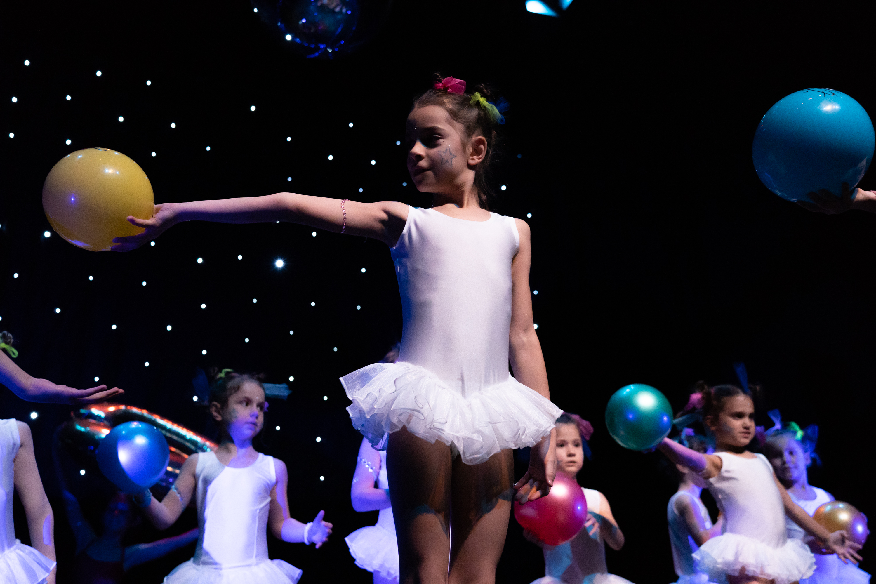 Bambina in tutù bianco con pallone giallo durante il saggio di Gym-Art-Dance della scuola Arte del Movimento e del Respiro